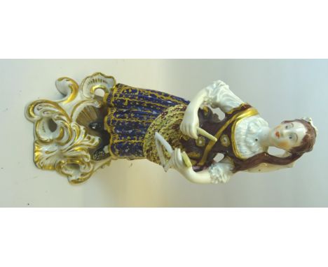 A 19th Century Continental standing female Figure playing a triangle, dress decorated in blue and gilt and on a rococo style 