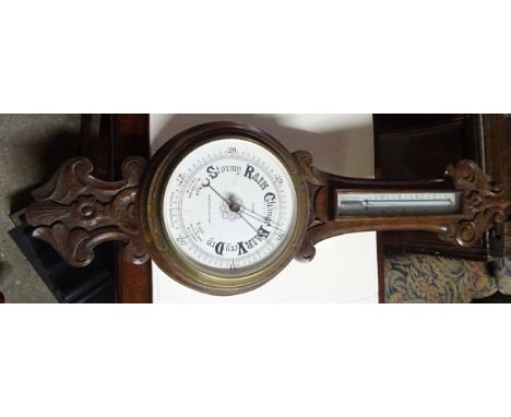 An Aneroid Barometer and Thermometer, the dial inscribed "R Clark, Newcastle-on-Tyne" in carved oak banjo pattern case.