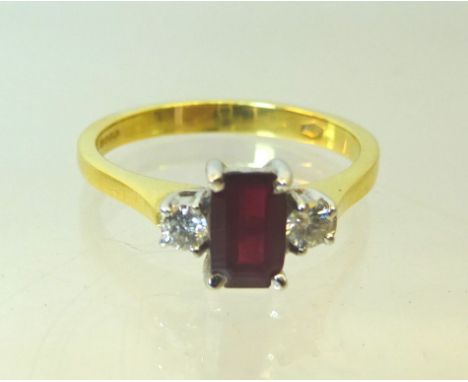 An 18ct. gold Ring set with an emerald cut ruby and two diamonds. 