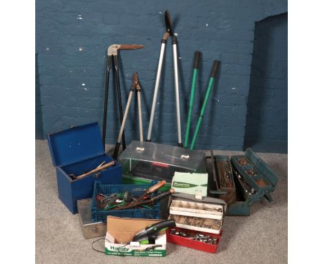 A collection of tools, garden tools and an outdoor lantern.  