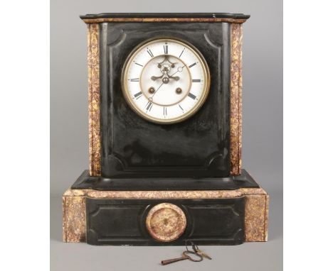 A black slate and marble mantel clock, with O. Berger movement on white enamel dial and Roman Numeral markers. With key.  