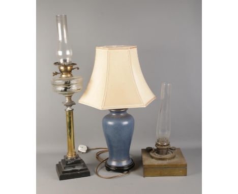 Two brass paraffin lamps and one ceramic modern table lamp.  