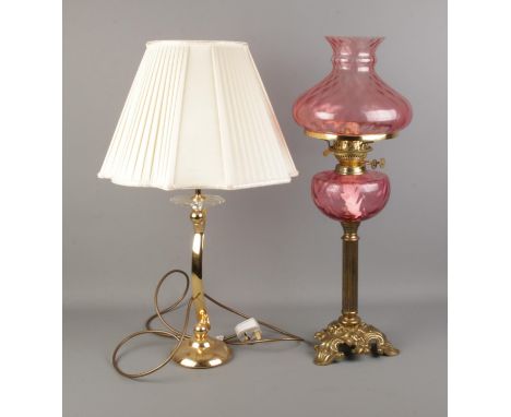 A decorative pink glass paraffin lamp with one other table lamp.  