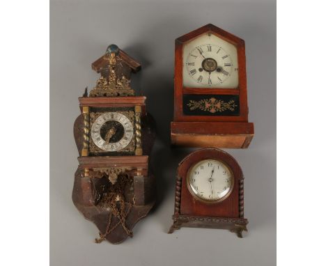 A Dutch wall clock featuring figure of Atlas with German eight day movement. Also two mantle clocks.  