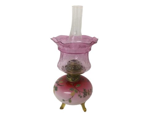 Unusual Victorian cranberry glass oil lamp with hand painted floral enamels on amber glass feet and cranberry etched glass sh