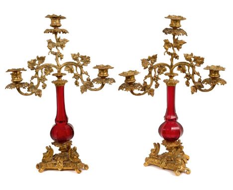 Pair of 19th century ormolu and ruby glass three branch candelabra, with removable sconces and scrolling foliage arms raised 