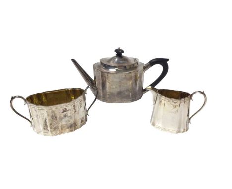 Composite three piece silver teaset in the Georgian style, comprising teapot of panelled form, with engraved borders, hinged 