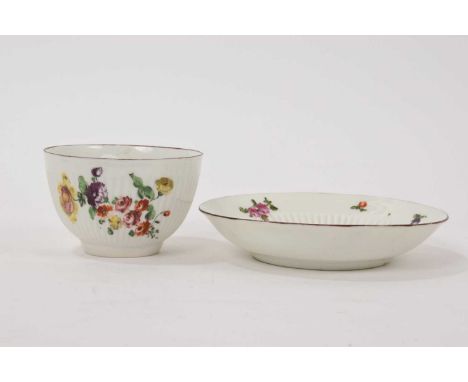 Derby ribbed tea bowl and saucer, circa 1758, polychrome painted with flowers, red-lined rims, the saucer 12.25cm diameterSom