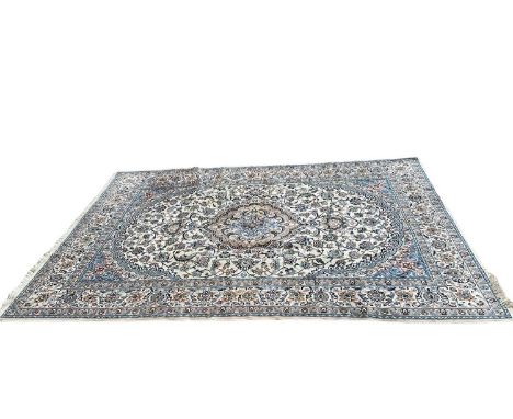 Large Nain carpet, the central radiating medallion on cream ground, in foliate meander borders with tassel ends, 313 x 212cm