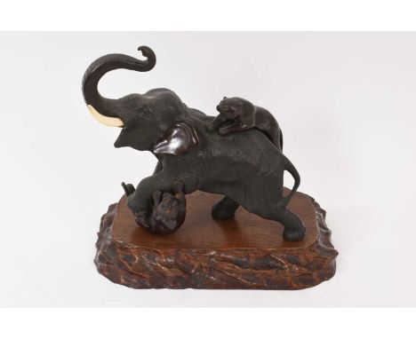 Late 19th century/early 20th century Japanese bronze sculpture of an elephant with two tigers, 24cm long, raised on carved wo