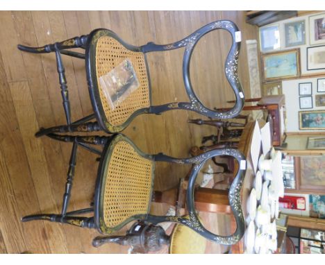 A pair of black lacquered Victorian balloon back chairs, with mother of pearl inlay, cane seat and turned outsplayed legs