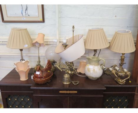 A wall mounted brass oil lamp, a pair of brass and glass table lamps and various other table lamps, bell, pottery jug and egg