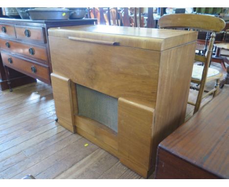 A 1930s walnut radiogram case, the hinged lid enclosing a Garrard R.C. 72 turntable, a speaker grille and two hinged doors be