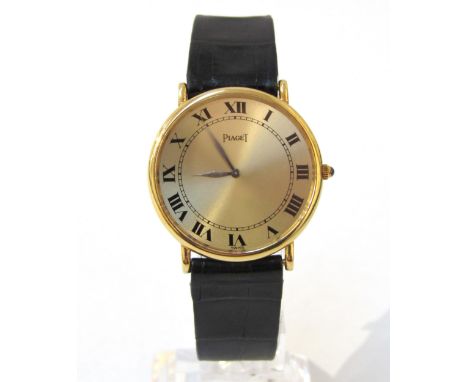 PIAGET: An 18ct gold thin cased Piaget wristwatch on Piaget reptile leather strap, champagne Roman numeral dial, blue stone c