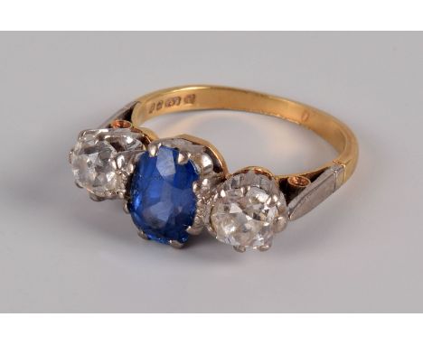 A nice modern three stone sapphire and diamond ring from Mappin & Webb, the oval light blue central stone and pair of old cut