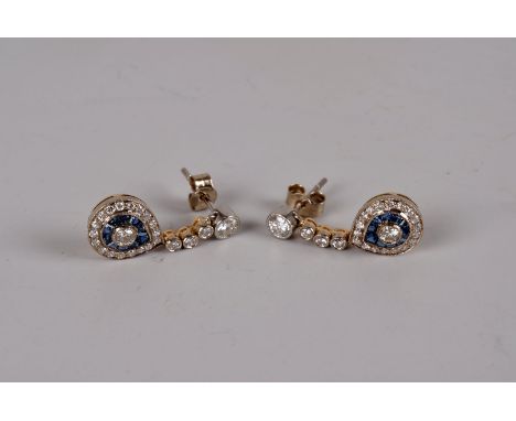 A fine pair of Art Deco style diamond and sapphire pendant earrings, having brilliant cut to the post and three further colle