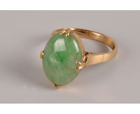 A modern Chinese hardstone and yellow metal dress ring, having an oval polished green jadeite stone in mount marked 14k, appr