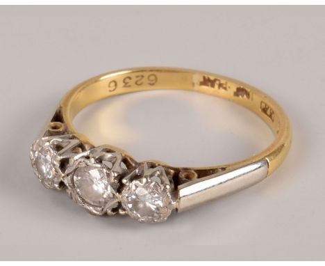 An Art Deco period three stone diamond ring, the brilliant cuts in platinum illusion mount on an 18ct gold band