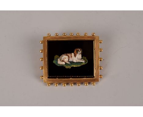A fine Italian Edwardian period gold and micro mosaic brooch cum pendant, the black pietra dura panel depicting a recumbent s