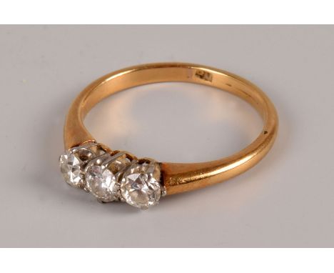 An Art Deco period three stone diamond ring, the old cuts in platinum claws on an 18ct gold band, approx 2.2g and size K