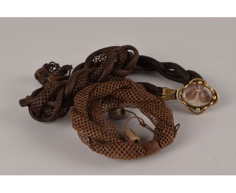 A group of three Victorian mourning bracelets, all with plaited hair chains, one with pinchbeck mounts and panel with lock of