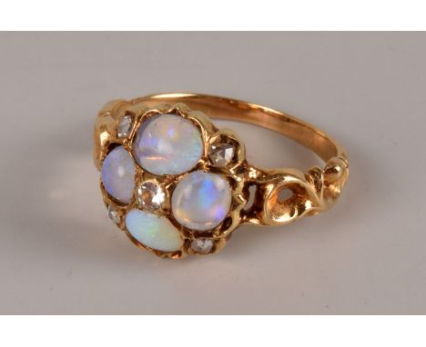 An antique style opal and diamond dress ring, the tablet set with four polished opals and centred with an old cut and also se