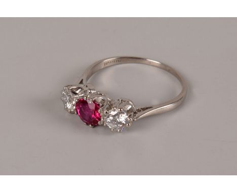 A nice Art Deco period three stone engagement ring, the platinum mount set with two brilliant cuts and a central red stone, p