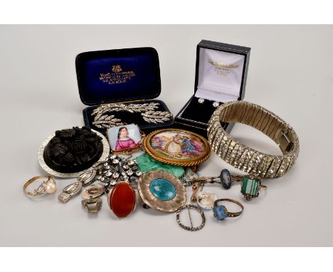 A collection of jewellery, including a yellow metal mounted porcelain brooch, a Chinese glass Art Deco pendant, a Whitby jet 