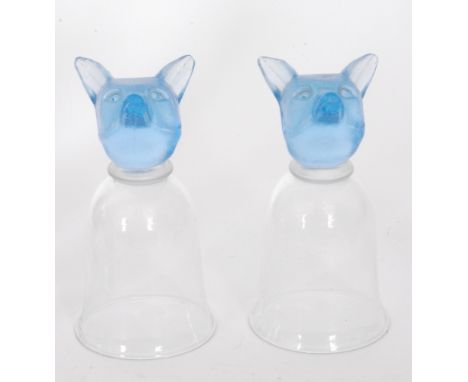 A pair of contemporary glass stirrup cups, the clear crystal bell form bowl above a fox head form finial in pale blue, height