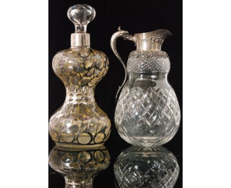 An early 20th Century Continental glass decanter of hourglass form with applied foliate silver overlay to the clear ground, h