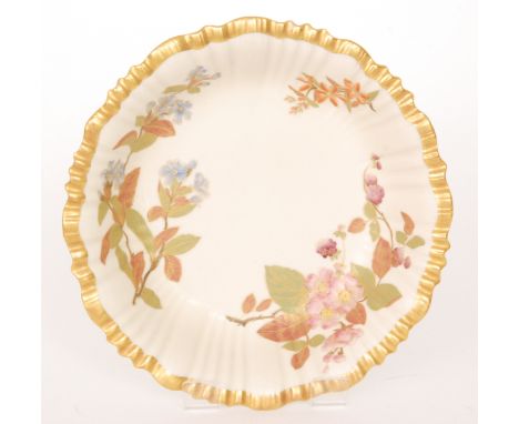 A Royal Worcester shallow bowl decorated with enamel and gilt blossoms and foliage against a faux ivory ground, puce mark wit