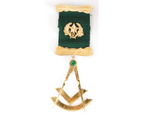 A yellow metal Masonic jewel Lodge Cameronians Edinburgh No 1563 with green stone to compass below green silk ribbon. 