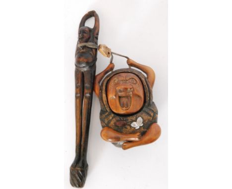 An early 20th Century Japanese carved wooden box or Inro modelled as a cross legged man with beetle and butterfly detail to b