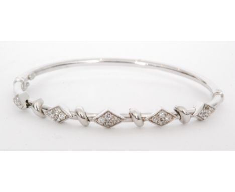 A 14ct white gold diamond set hinged bangle five pave set lozenge shaped panels to a tubular bangle, S/D. 