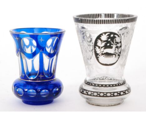 A late 19th Century Bohemian spa beaker of flared form with black enamel flashed cartouche panels and borders engraved with a