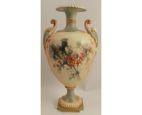 A Royal Worcester blushed ivory two handled vase, raised on a pedestal, decorated with thistles and flowers to a blushed ivor