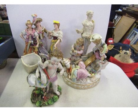 A German model of a child with a stork, together with a continental figure of three girls with baskets of flowers, and a cont