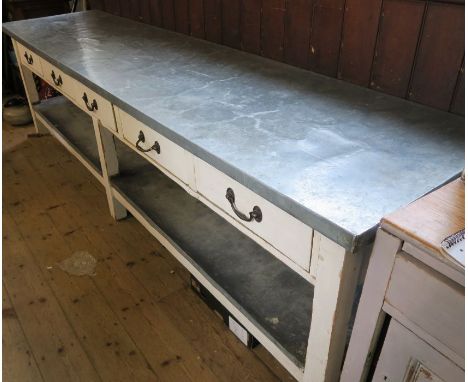 An Antique painted pine work bench, with metal cover to the top and under shelf, fitted with five frieze drawers, width 116in