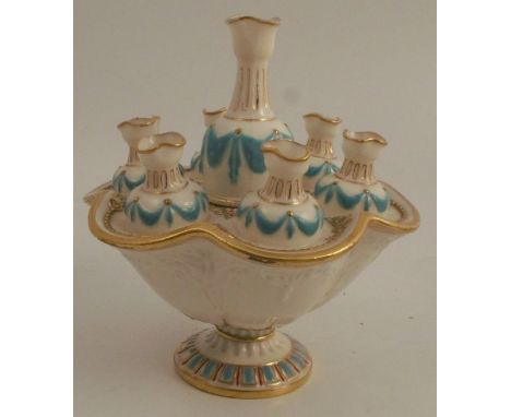 A 19th century unmarked Worcester porcelain bud vase, formed as a central urn surrounded by six smaller urns, in a shaped cir