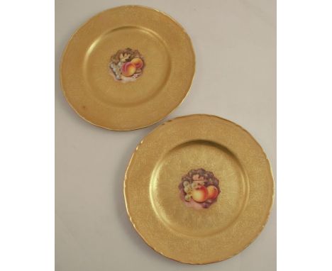 Two Royal Worcester plates, decorated with central panels of fruit by Reed, to an acid etched gilt border, diameter 10.5ins -