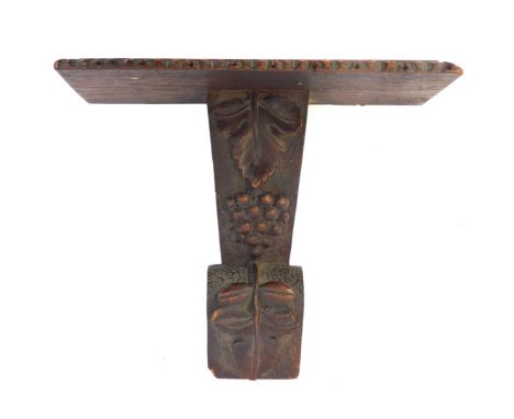 A 19thC oak wall bracket, rectangular shelf with a carved border, raised on a carved column decorated with vine leaves and gr