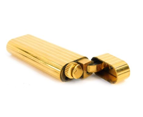 A Must De Cartier gold plated lighter, of ribbed design, serial number 28170B, 7cm high. 