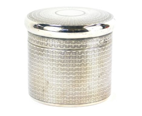 A George V silver dressing table jar and cover, of cylindrical form, with waved engine turned decoration, by Goldsmiths and S