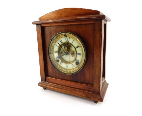 A late 19thC/early 20thC oak cased mantel clock, the circular enamel dial bearing Roman numerals, brass chapter ring, eight d