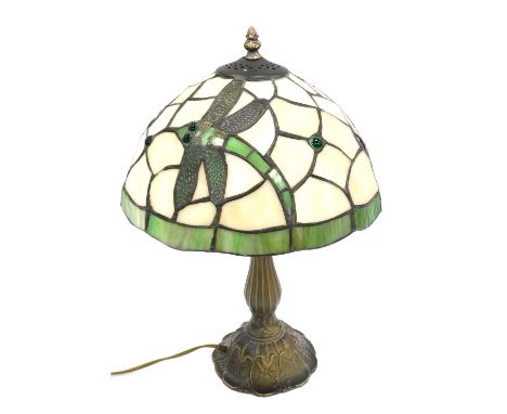 A Tiffany style table lamp, the leaded glass shade decorated with dragonflies against an off white and green ground, on a bra