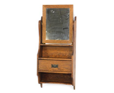 An Edwardian oak hanging wall shelf, the mirror top above two shelf sectional, with central single drawer, 83cm high, 36cm wi