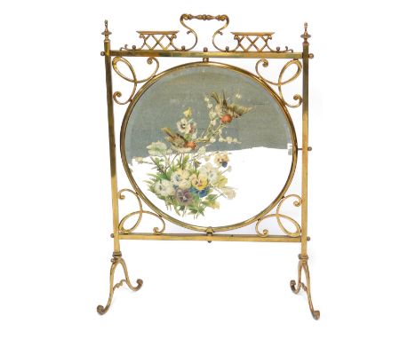 A brass Arts and Crafts fire screen, of rectangular shape with a central mirrored panel, hand painted with birds and flowers,