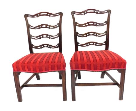 A pair of 19thC mahogany side chairs, each with a pierced ladder back and a red upholstered padded seat with striped fabric, 