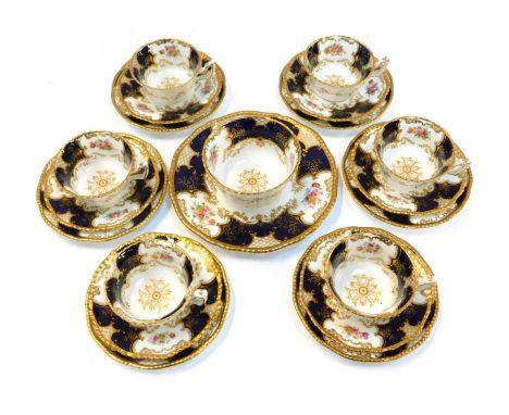 A Coalport porcelain part tea set, decorated with reserves of flowers between dark blue panels, gilt heightened, comprising s