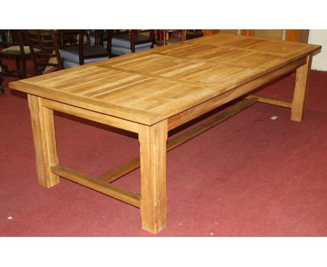 A large contemporary light oak rectangular refectory table, having a planked and cleated top, raised on a heavy square slight